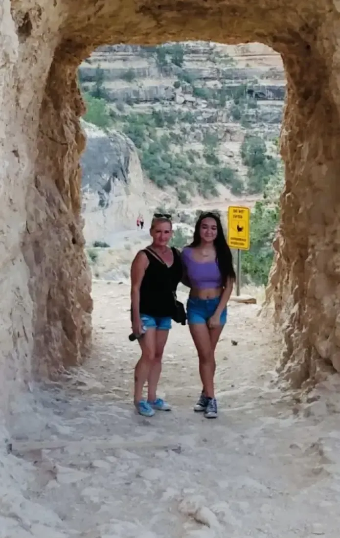 Two friends in a rock tunnel at the Grand Canyon