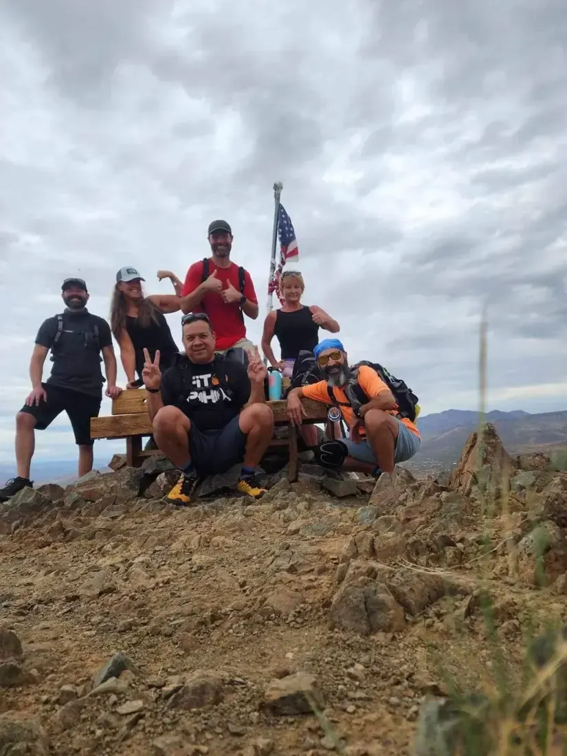 Hiking group at the summit with a flag