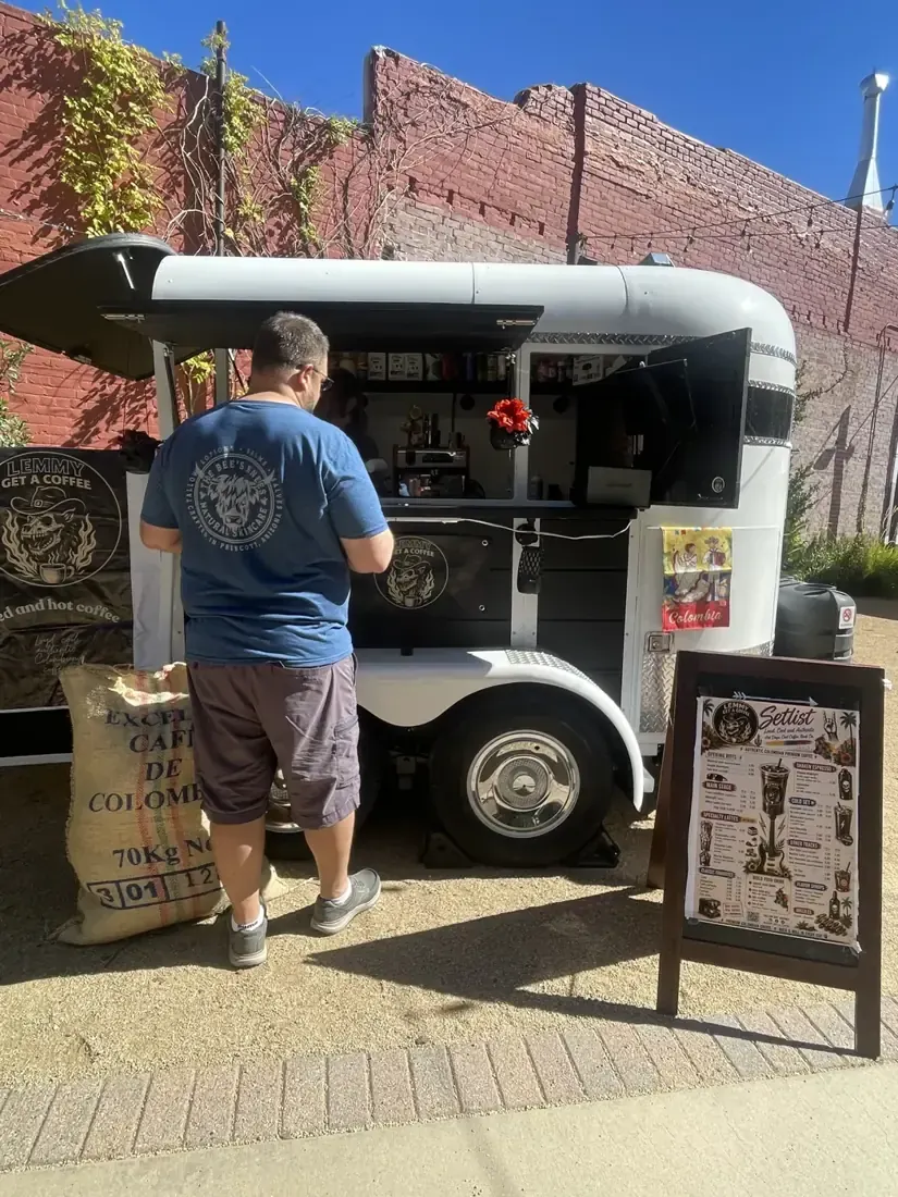 A coffee trailer with a customer at the window