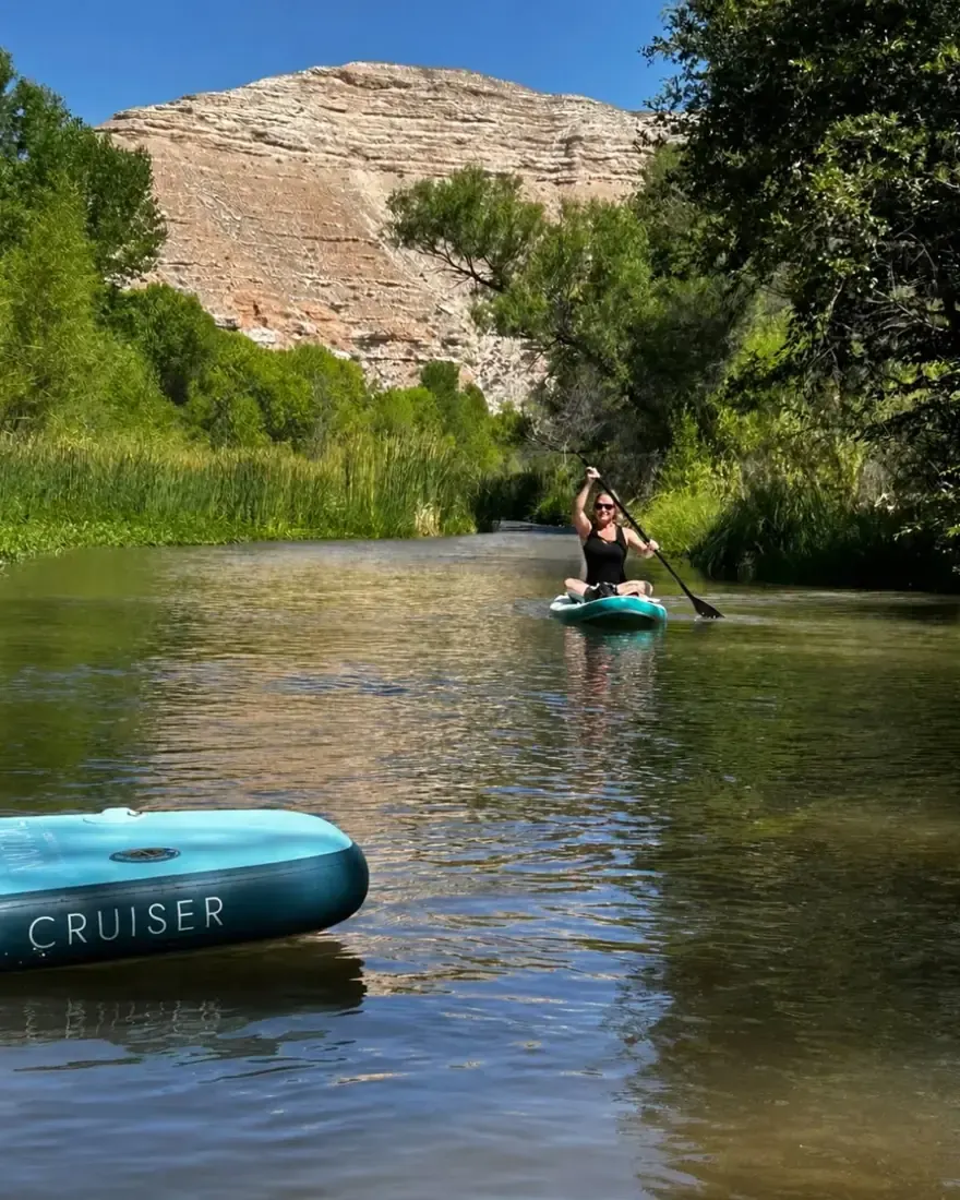 A paddler on the Verde River between green banks