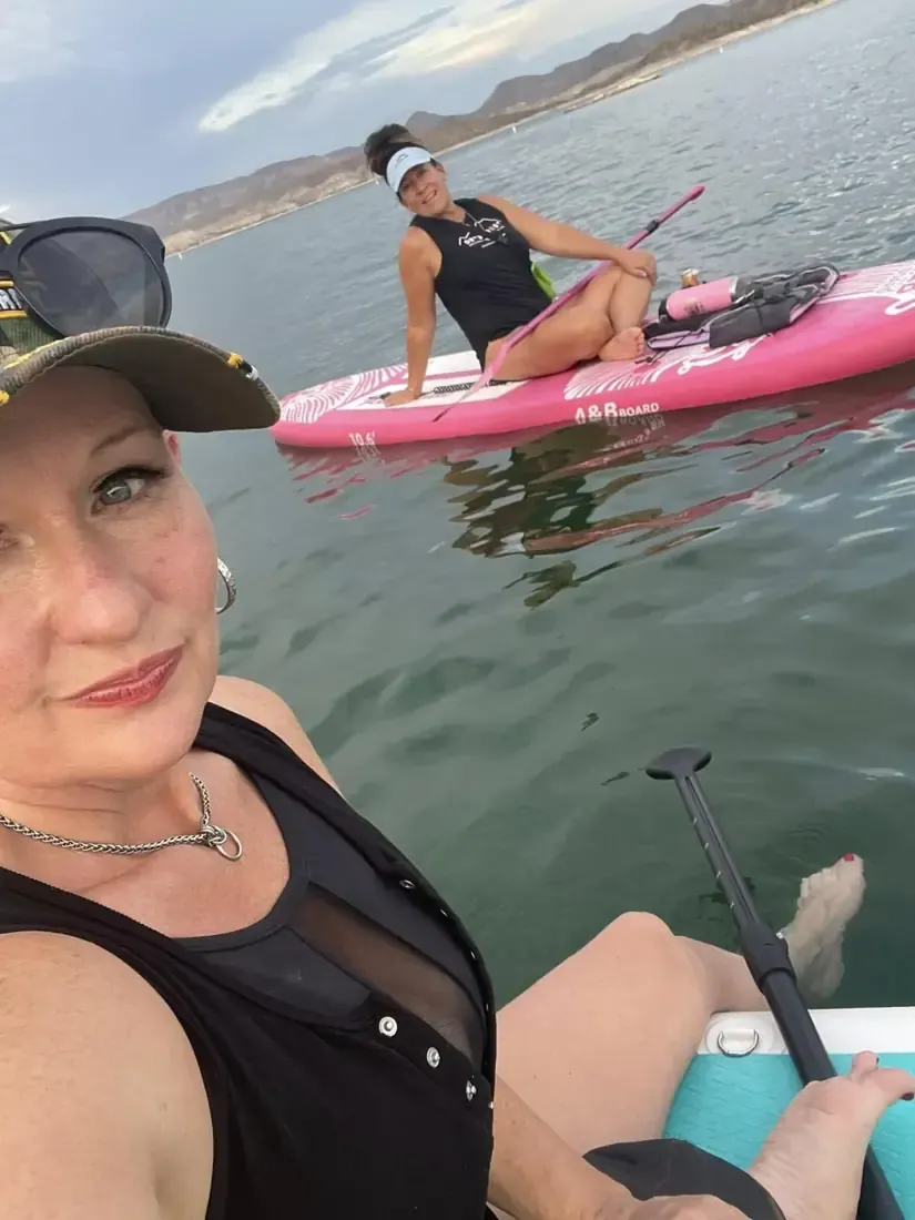 Selfie from a paddleboard, another paddler on a pink board behind